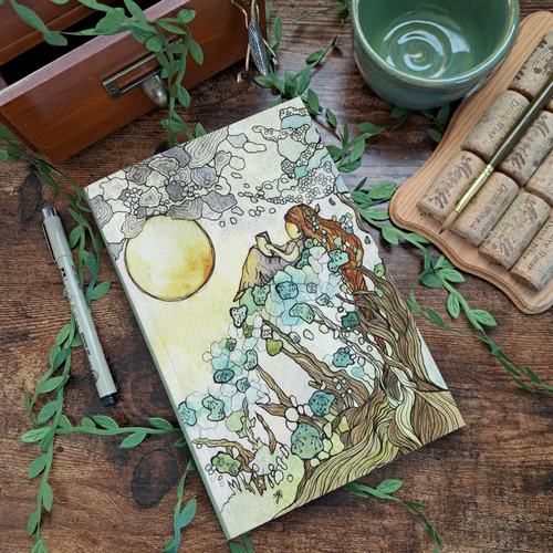 Never Forget the Way art journal by Fox Jot Studio, flatlay on warm wood surface with green leaves and pen